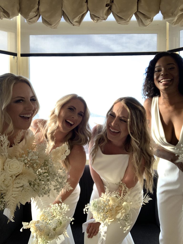 4 brides laugh and smile into the photobooth camera 