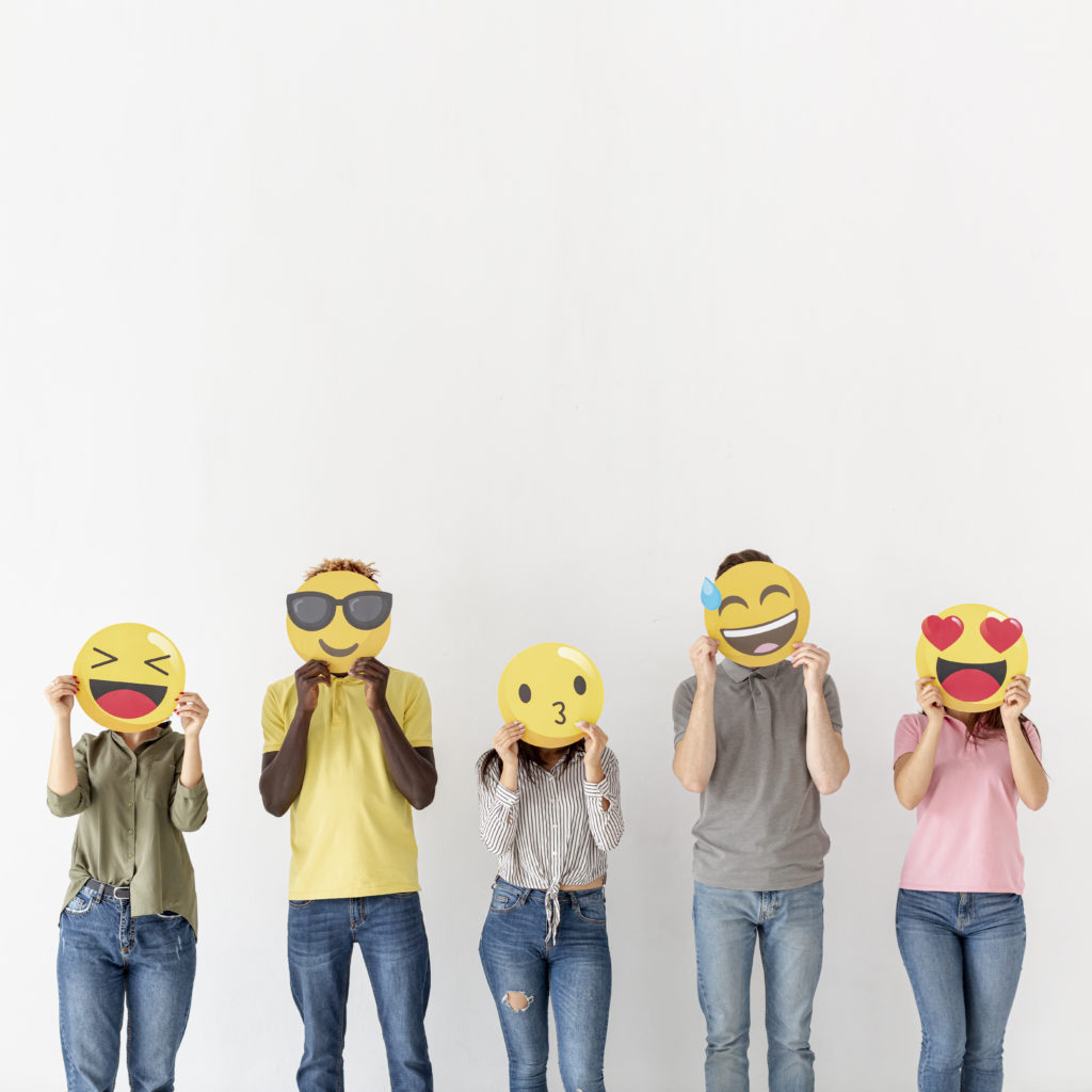 5 people hold emoji photo booth props over their faces 