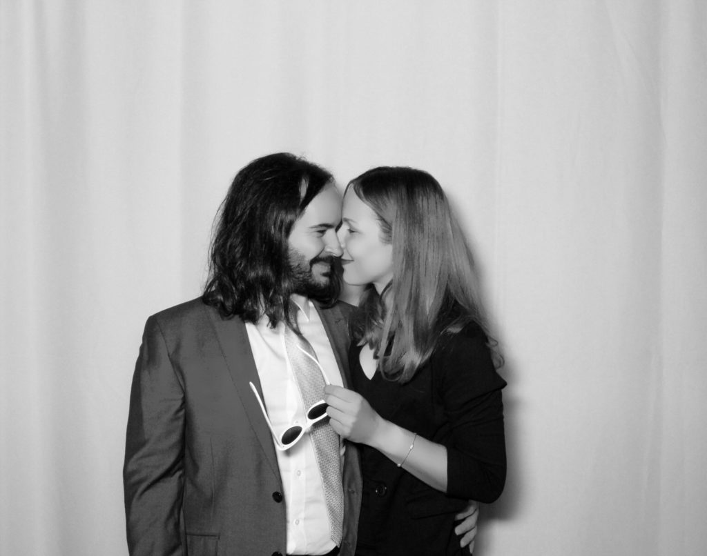 man and woman embrace one another in wedding photobooth
